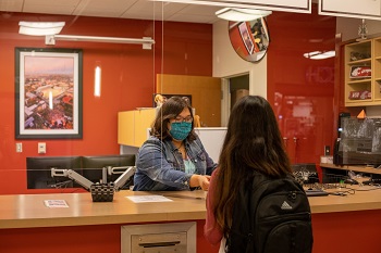 Student getting a new CougarCard from a staff member at the CougarCard Center