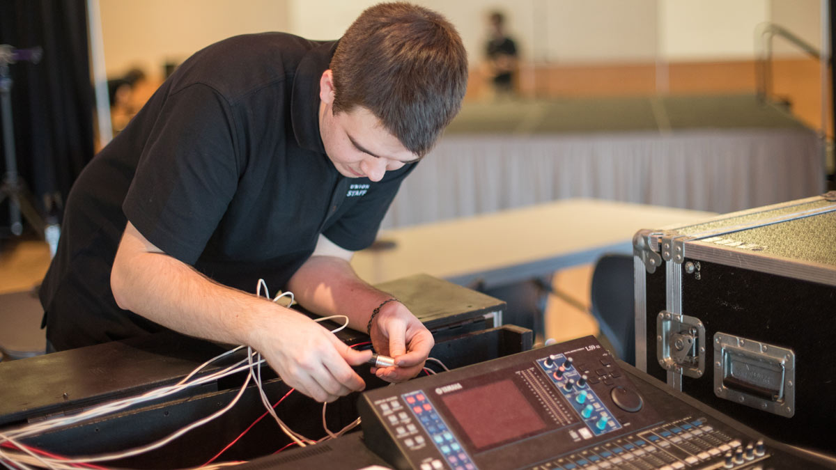A CUB staff member works with audio equipment