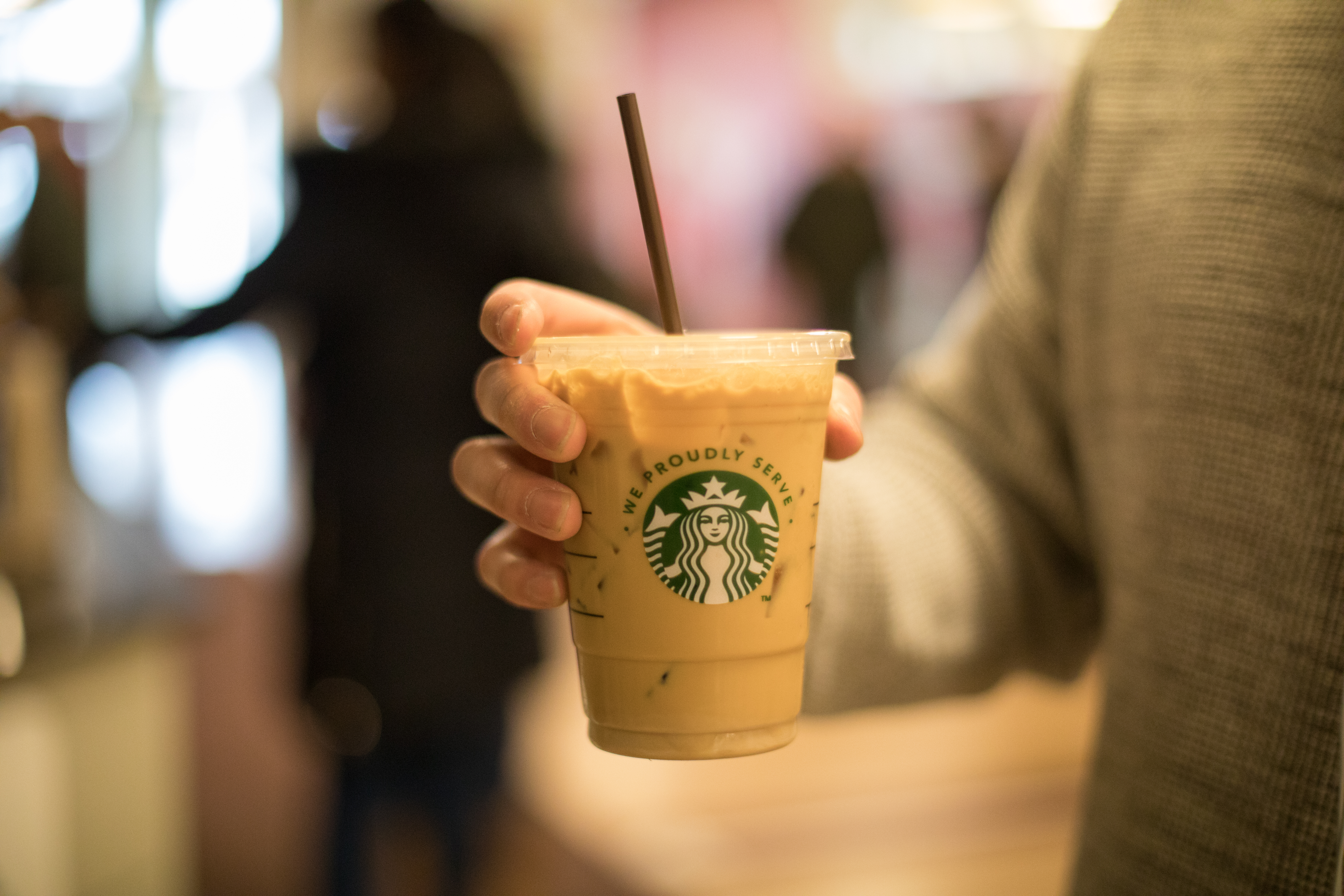 Hand holds iced coffee beverage