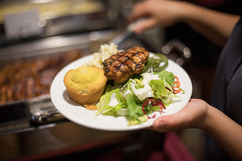 Caterer putting food on plate.